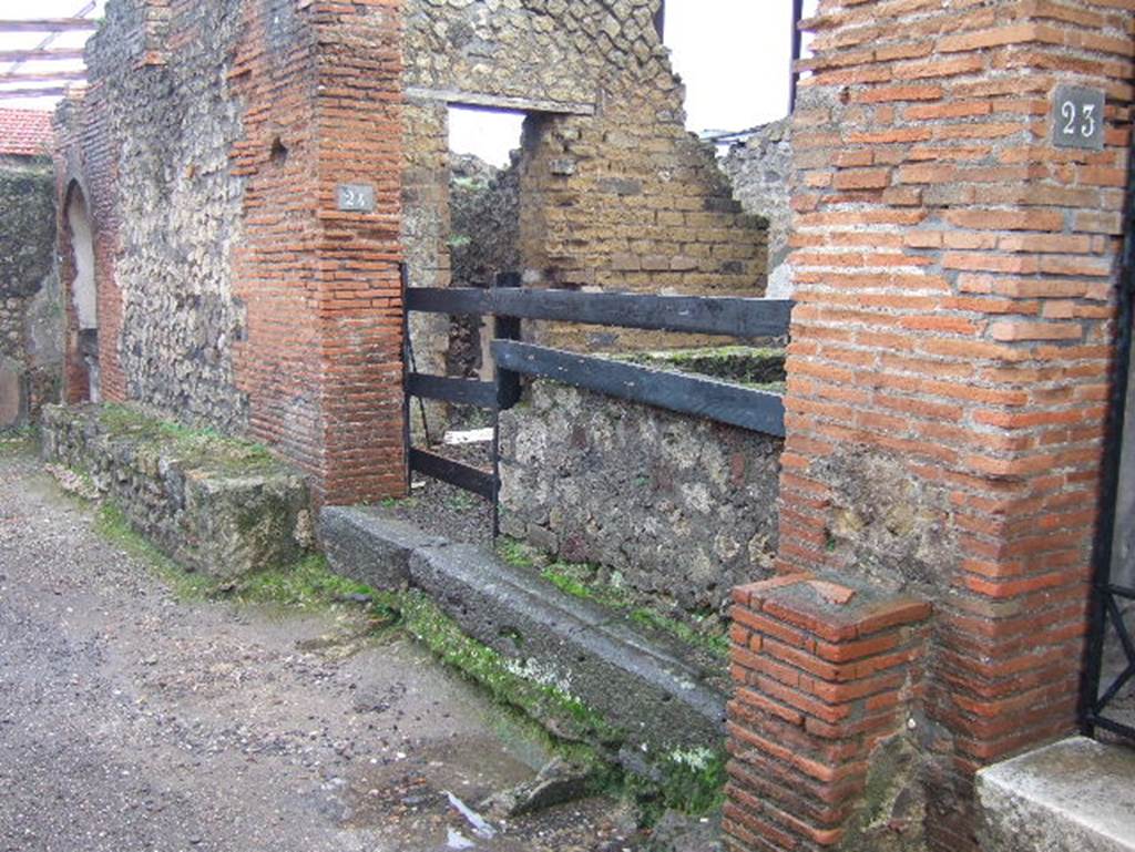 VIII.2.24 Pompeii. December 2004. Looking east to doorway, and bench outside. In the east wall of the bar can be seen a doorway, this led into the kitchen with hearth and latrine. See Eschebach, L., 1993.  Gebäudeverzeichnis und Stadtplan der antiken Stadt Pompeji. Köln: Böhlau. (p.358)
