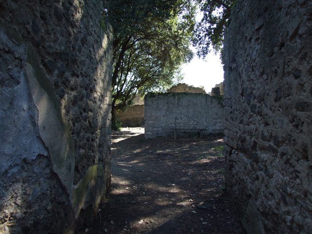 VIII.6.6 Pompeii. December 2007. Niche in south-west corner.
According to Boyce, this simple aedicula consisted on a podium and a niche with an arched opening. The interior of the niche is an unusual pentagonal shape, the floor is paved with red stucco ornamented with little white stones. The rest of the structure was uniform white, except for the tympanum, which was yellow with a star in white relief in the middle. Before the shrine and close to the south wall, stood a small masonry altar, originally coated with white stucco. See Boyce G. K., 1937. Corpus of the Lararia of Pompeii. Rome: MAAR 14. (p.78, No.374, Pl.33,1)