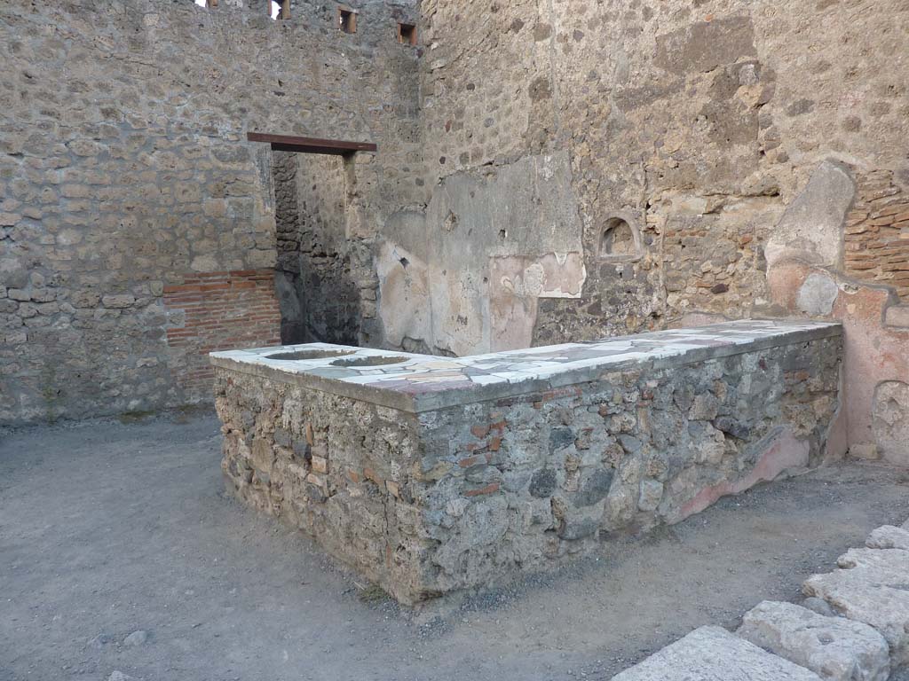 IX.1.16 Pompeii. September 2018. Looking east across counter towards wall with niche. Photo courtesy of Aude Durand.