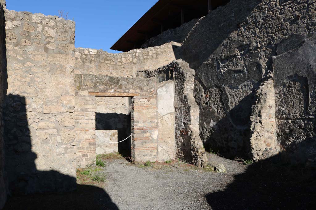 IX.1.18 Pompeii. December 2018. 
Looking towards doorway to cubiculum, centre left, and doorway to a rustic storeroom or cupboard in north-east corner of yard, on right.
Photo courtesy of Aude Durand.
