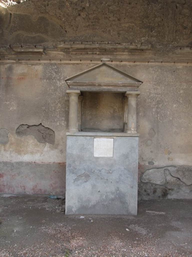 IX.1.20 Pompeii. December 2007. Room 6, household shrine in ala on east side. According to the description from Boyce, the base was covered with stucco and painted in imitation of red and yellow marble.
Around the top of the base ran a red stripe. In the centre of the front was embedded a white marble slab with the inscription, below.
The lararium painting was done on the white background of the room walls, on both sides of the aedicula. On the right side, two male figures, each clad in a long white garment like the toga, stood beside an altar.
On the left of the aedicula three men lead a bull to sacrifice; one leading the animal by a rope, the other two held him. See Boyce G. K., 1937. Corpus of the Lararia of Pompeii. Rome: MAAR 14. (p.79-80)
See Helbig, W., 1868. Wandgemälde der vom Vesuv verschütteten Städte Campaniens. Leipzig: Breitkopf und Härtel. (59b)
