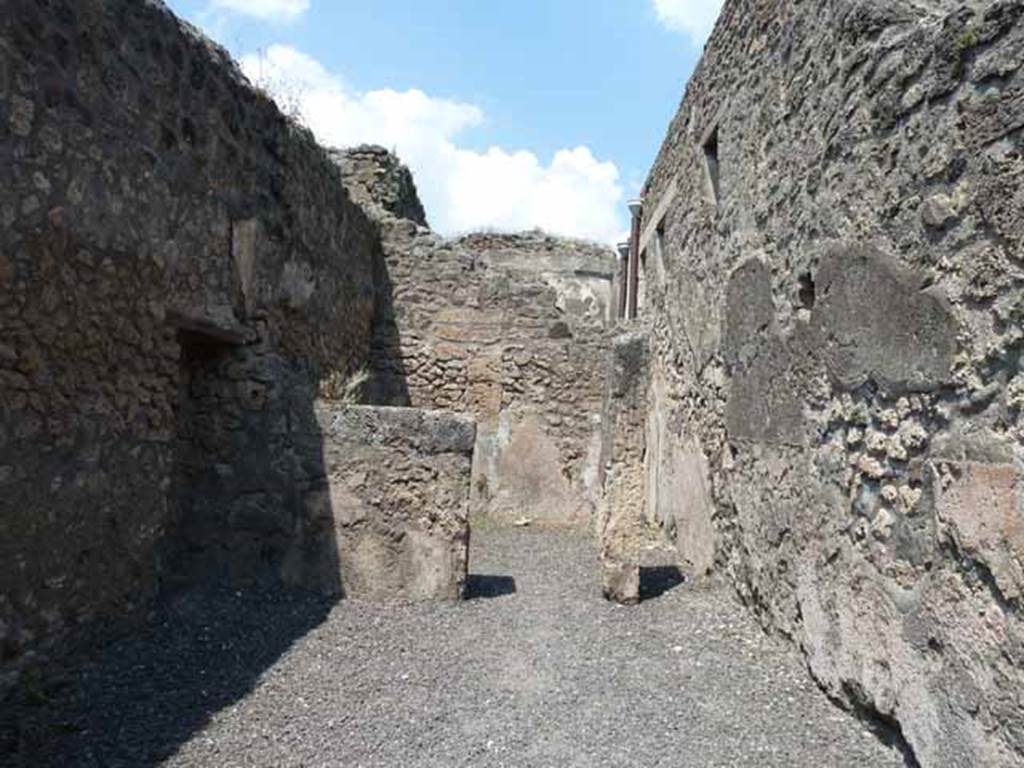 IX.1.24 Pompeii. May 2010. Looking north across shop towards doorway to rear room, and steps to upper floor, on right.