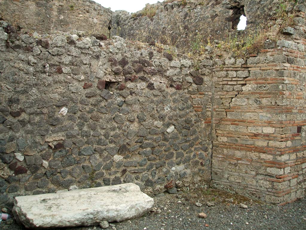 IX.1.32 Pompeii. May 2005. 
Site of steps to upper floor against east wall of atrium. The base of the steps can just be seen in the south-east corner, centre-right.
According to Warscher, “the large white block of tufa seen in the above photo was probably one side of the impluvium of the atrium of IX.1.32”.

