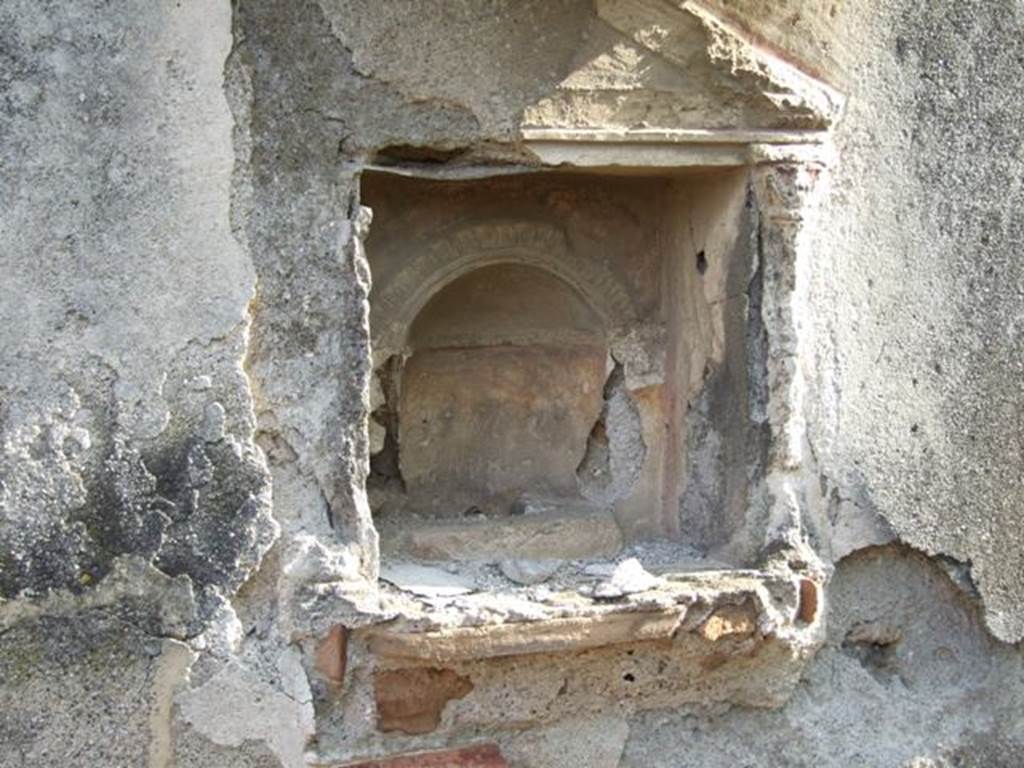 IX.2.21 Pompeii. March 2009. Room 11, south wall with aedicula shrine, and remains of stucco interior. Boyce said below the niche was a heavy ledge, richly adorned with complex triple frieze of various designs of polychrome modelled stucco. Upon it rested the bases of applied half-columns with capitals that supported the pedestal. All three cornices surrounding the tympanum were decorated with stucco friezes. The whole faade was decorated with red stripes against the white stucco background.
