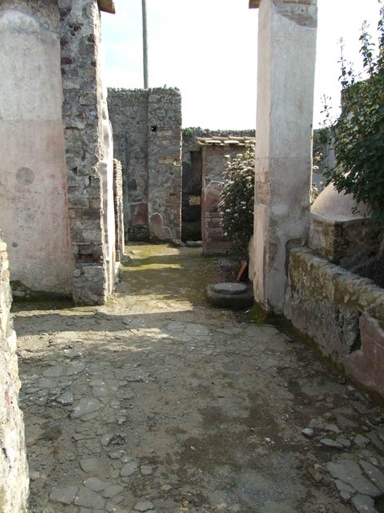 IX.3.5 Pompeii. March 2009. Room 21, corridor, looking south. Large doorway to room 20, on left.  According to Dyer: The peristyle is surrounded on two of its sides with square columns, painted with plants on a red background. The pillars are connected together by a low wall, which leaves two openings into the xystus, or garden. On the other sides it is bounded by the tablinum in front, and by an exedra or oecus, on the right (of the peristyle).
See Dyer, T., 1867. The Ruins of Pompeii. London: Bell and Daldy. (p.85)
