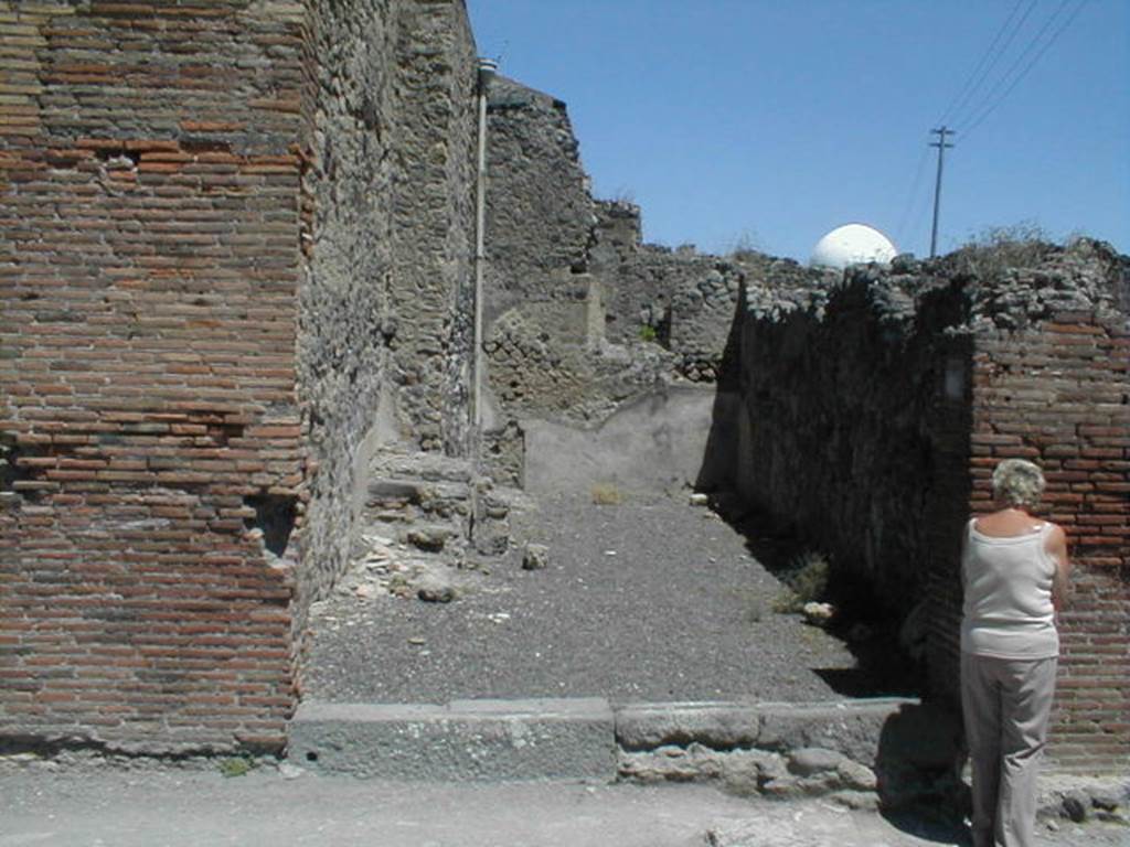 IX.3.7 Pompeii. May 2005. Entrance, looking east from Via Stabiana.
According to Fiorelli, this shop was very deep, and inside had stairs to the mezzanine above with the niche of the Penates, near to which was found that painting depicting Isis-Fortuna on the globe, the god Luno on horseback, and winged Esperus carrying a torch: at the top one read -
 
See Fiorelli, G., (1875). Descrizione di Pompei, (p.394)
See Pappalardo, U., 2001. La Descrizione di Pompei per Giuseppe Fiorelli (1875). Napoli: Massa Editore. (p.146)
See Bullettino dellInstituto di Corrispondenza Archeologica (DAIR), 1847, p. 127-8.
