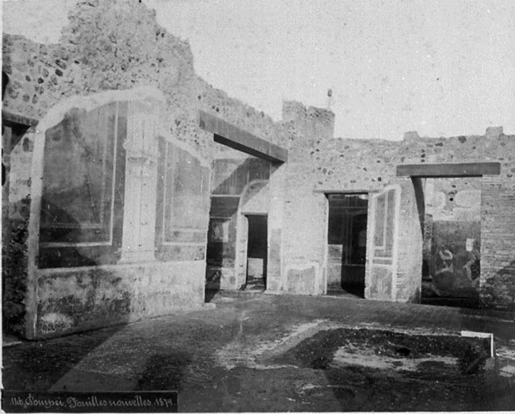 IX.5.14 Pompeii. Old photograph, c.1880.
Looking north-east across atrium, with remains of the impluvium in the floor of cocciopesto dotted with small crosses of white tesserae, with black centre.
Room e an ala, with doorway to room d, can be seen in the centre, then to its left  the doorway to room c, and entrance corridor a, on the right.
