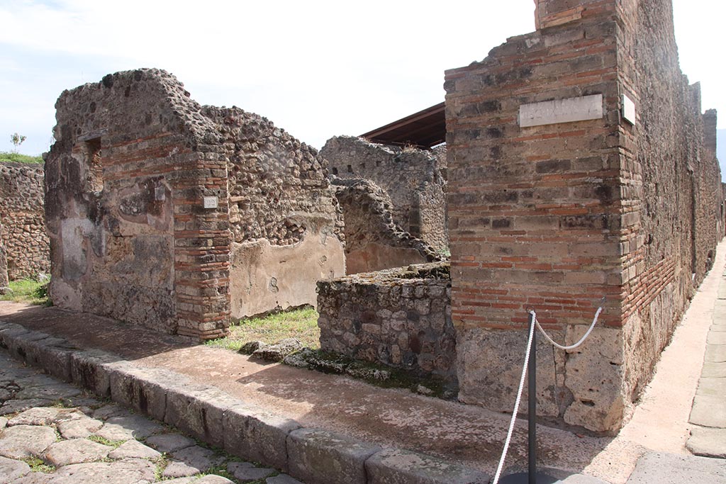 IX.7.22 Pompeii. October 2024. 
Looking south-east to entrance doorway, on corner with Vicolo di Tesmo, on right. Photo courtesy of Klaus Heese.
