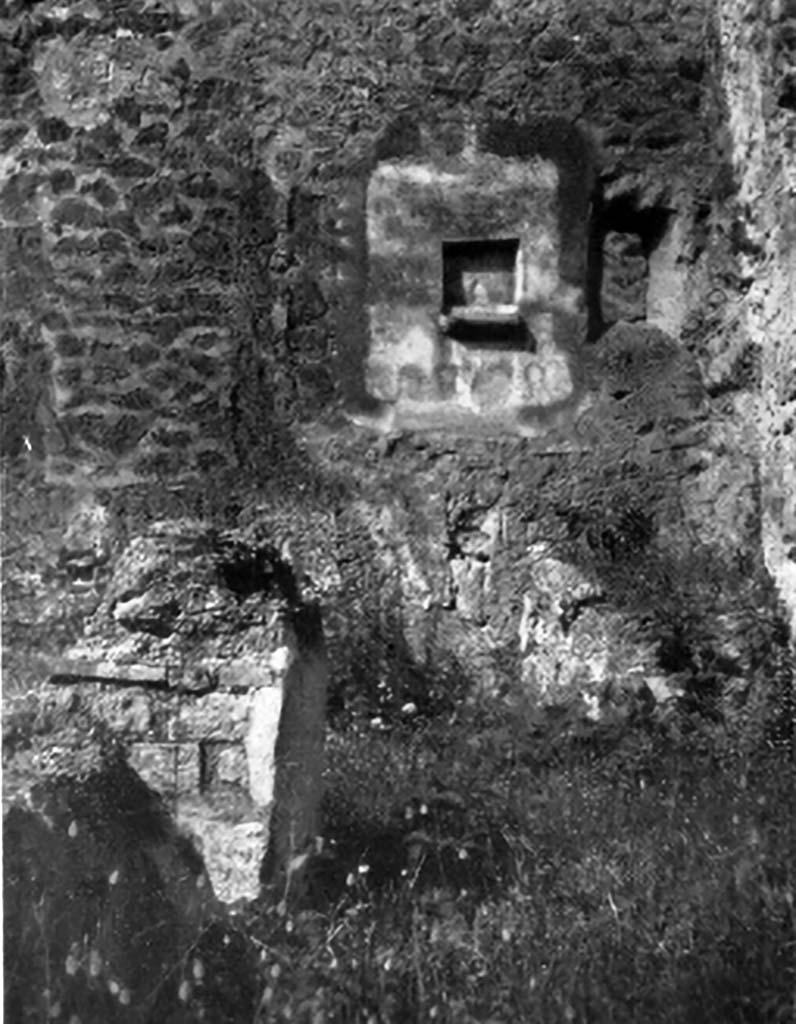 IX.7.21/22 Pompeii. 1937. Lararium in north-west corner of atrium of IX.7.21.
According to Boyce, in the north-west corner of the atrium was the hearth.
Above the hearth in the west wall was a panel of white stucco. In the panel was a square niche.
Its edges were outlined in red against the white background and below it was a cornice.
On the reddish coloured back wall of the niche was painted a white object, which Mau was unable to identify.
He did state that it was not a phallus.
Below the niche was a painted garland of red and green leaves and below it a burning altar with a pine-cone.
On either side of the altar was a yellow serpent.
The serpent on the left had a red crest and beard, the head of the other was damaged.
See Boyce G. K., 1937. Corpus of the Lararia of Pompeii. Rome: MAAR 14.  (p.88, no.441, and Pl.4, 4)
According to Giacobello, the painting is no longer conserved.
See Giacobello, F., 2008. Larari Pompeiani: Iconografia e culto dei Lari in ambito domestico. Milano: LED Edizioni. (p.250)
See Mau in Bullettino dellInstituto di Corrispondenza Archeologica (DAIR), 1882, (p.195)
