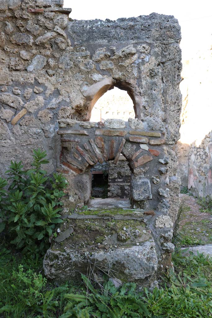 IX.7.25 Pompeii. December 2018. 
Looking north into IX.7.24, from north-west corner of atrium. Photo courtesy of Aude Durand.
Below the rear of the arched niche are the remains of the hearth. 
