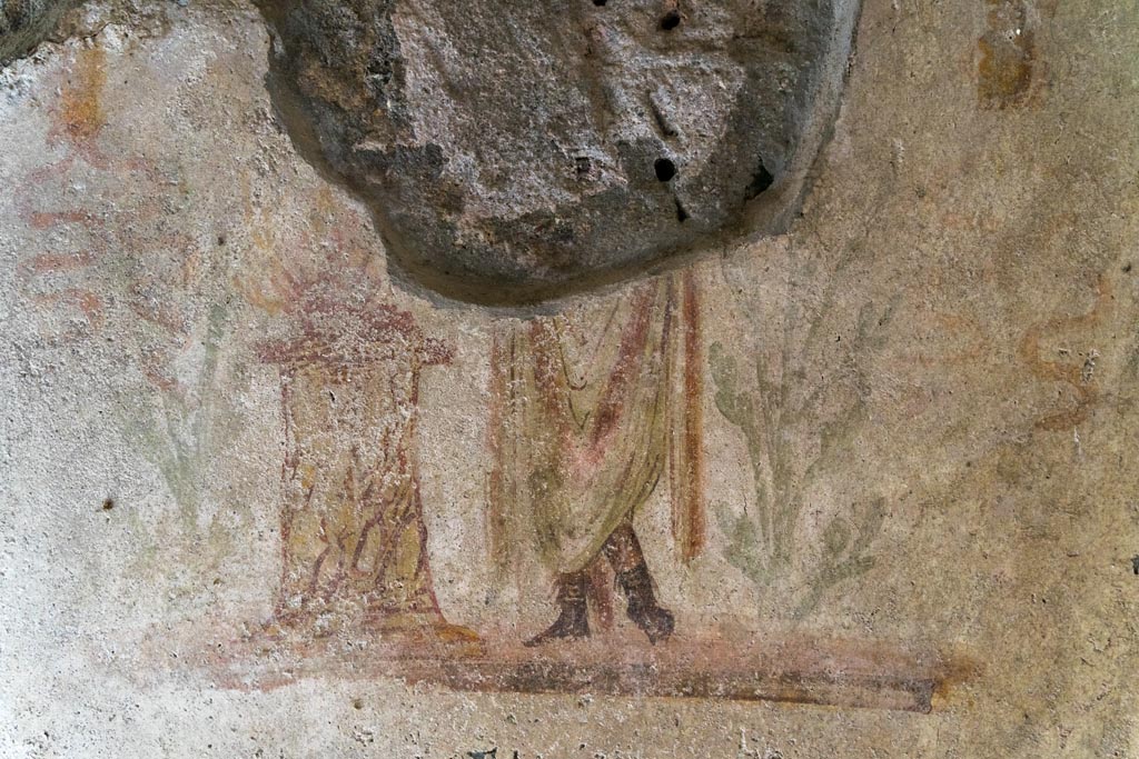 IX.9.c Pompeii. March 2023. Detail of Genius next to a round altar on west wall of kitchen area. Photo courtesy of Johannes Eber.