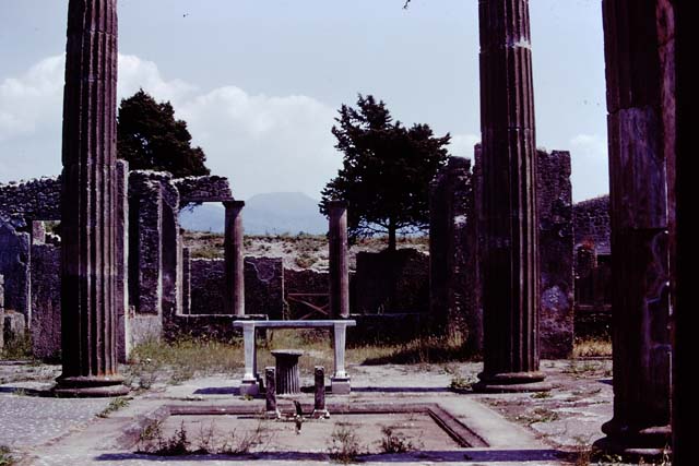 IX.14.4 Pompeii. Old undated photograph. Tetrastyle atrium B. Impluvium with marble table (e), basin (d), puteal and satyr fountain statue (c).