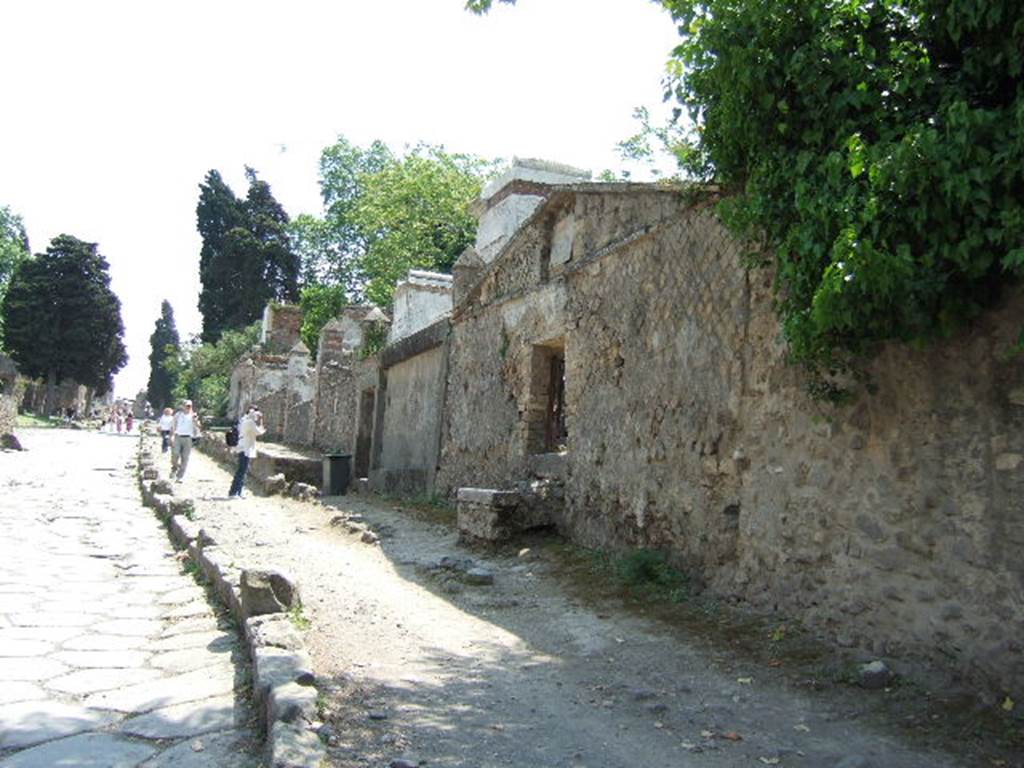 HGW24 Pompeii. May 2006. Looking south along Via dei Sepolcri. 
According to the plan by La Vega, nos 98 and 99 were found on this side of the roadway.
From PAH, addendum, p.133 – 
Relazione delle antichita, che si vanno ritrovando nella masseria del sig. D. Giovanni Milano parsonaro, che si era principiata al di 14 Febbraro 1771. (Report of Antiquities found.....)
N.98. A di 12 gennaio 1775. Si e trovata in una tavola di marmo larga pal. 2 on. 4 ½ per pal. 1 on. 11 la seguente iscrizione:
CN VIBRIO Q F FAL SATURNINO CALLISTUS LIB
From PAH addendum, p.160 - 
14 Gennaio 1775 – Altro sepolcro di Cn. Vibrio Saturnino; no. 98 pianta di La Vega.
28 Gennaio 1775 – Il medesimo contiene un triclinio.

(Fontaine, South of villa façade, west side of roadway, (see HGW23).

From PAH, addendum, p.133 – 
Relazione delle antichita, che si vanno ritrovando nella masseria del sig. D. Giovanni Milano parsonaro, che si era principiata al di 14 Febbraro 1771. (Report of Antiquities found.....)
N.99. Nel mese di aprile 1790 per le acque cadute si e fatto un fosso nel sito contrassegnato, e nel muro vi erano i seguenti caratteri alti pal. 2 ¼, e che di seguito dagli antichi erano stati imbiancati, e sono GABINIG…….. Si e fatto riempire il fosso, e l’iscrizione resta ove si e veduta.

(Fontaine, North of 98, south of villa façade, west side of roadway, (right side of photo).
