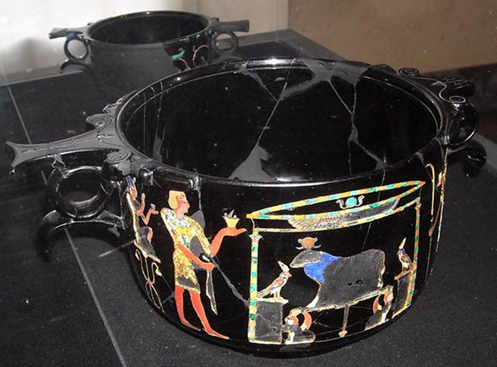Castellammare di Stabia, Villa San Marco, Found May 1954, room 37, near the south east wall. Obsidian skyphos (cup) B, with Egyptian scene of ram worship inlaid in gold and mosaic, after restoration in 2012.