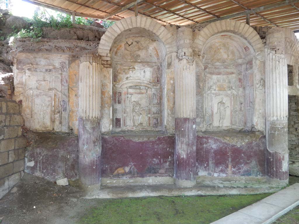 Villa San Marco, Stabiae, June 2019. 
Area 65 at southern end of west portico with curving wall of a nymphaeum, divided into eight niches.
Photo courtesy of Buzz Ferebee
On the right is the doorway to area 63. 
Each niche was stuccoed. In the niche 1, on the right, Venus can be seen.
Next to her in niche 2, Neptune can be seen.
Next to him in niche 3 was Fortuna.
In the central niche on this side was a mosaic representing Phrixus and Elle, discovered 30th April 1752, a copy of which can be seen in the photo above.
The original mosaic is now in the Naples Archaeological Museum, inventory number 10005.
See Pagano, M. and Prisciandaro, R., 2006. Studio sulle provenienze degli oggetti rinvenuti negli scavi borbonici del regno di Napoli. Naples: Nicola Longobardi. (p. 239).
