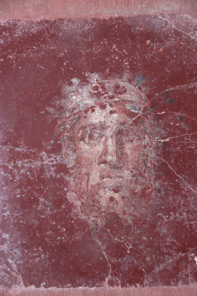 Villa San Marco, Stabiae, September 2019.  
Room 44, detail of painted face from east wall in south-east corner. Photo courtesy of Klaus Heese.

