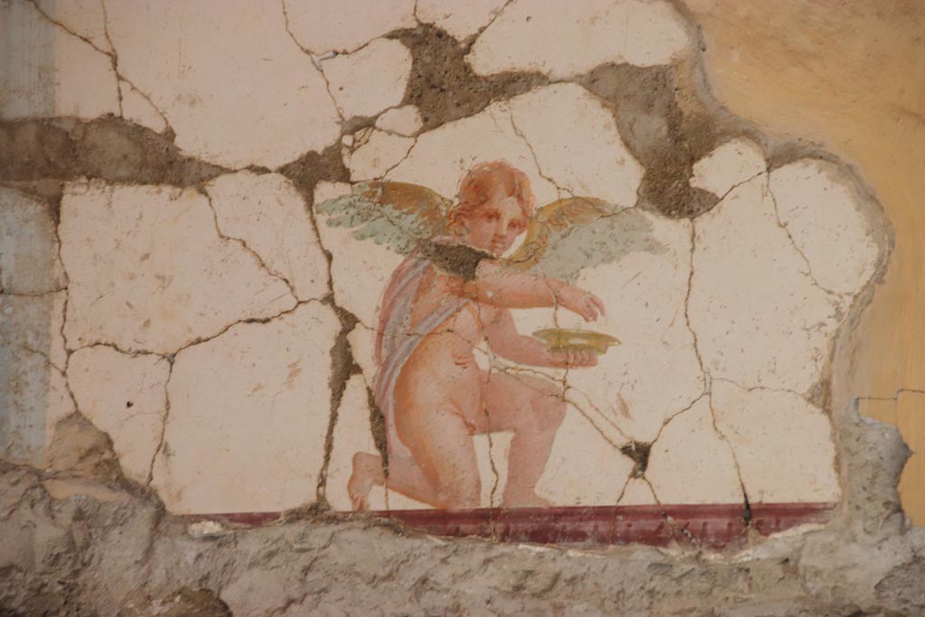 Villa San Marco, Stabiae, October 2022.  
Room 30, painting of kneeling Eros holding a dish, from east wall above doorway to room 50, in north-east corner.  
Photo courtesy of Klaus Heese. 
