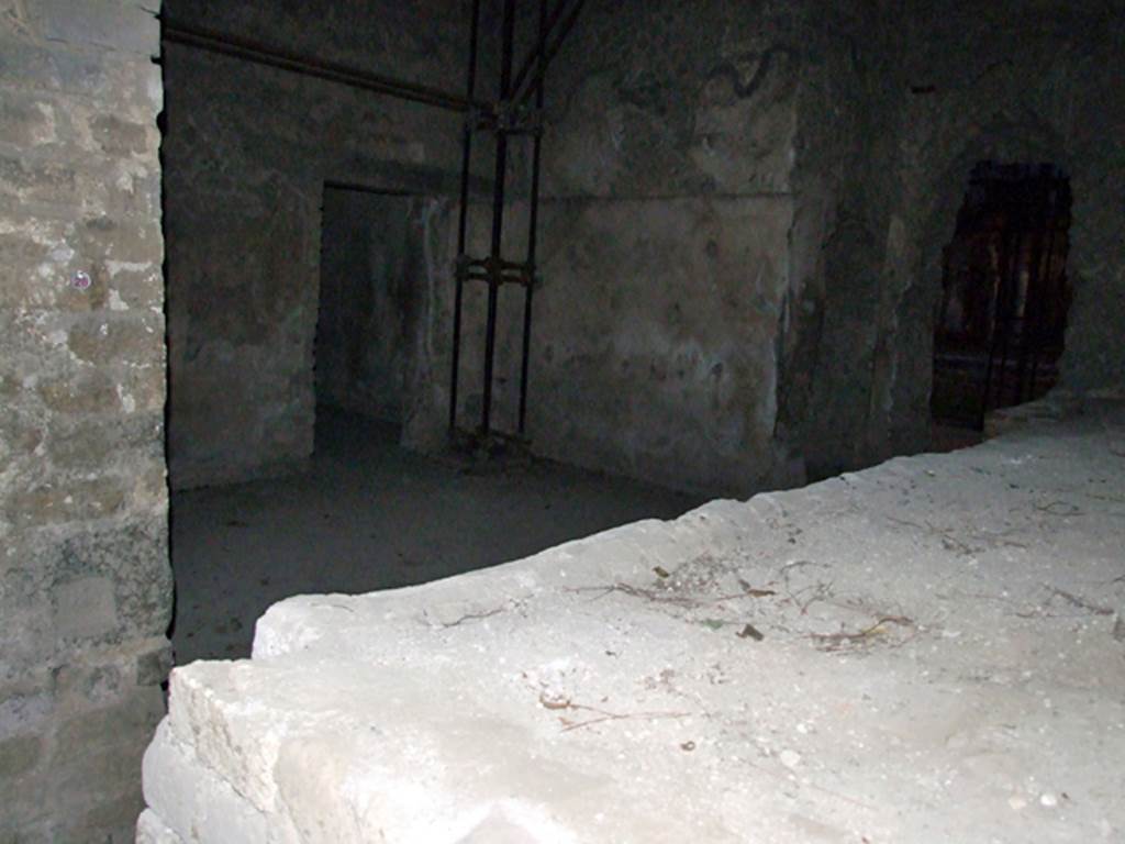 Villa San Marco, Stabiae, December 2006. Room 26, kitchen with doorway to room 40, left of centre. 
Room 40 also leads into corridor 49 on south side of atrium.
On the right can be seen the hole tunnelled through the west wall of the kitchen in the 18th century, from room 20. Immediately to the left of that is another hole into narrow room 27.
Looking south across top of hearth.


