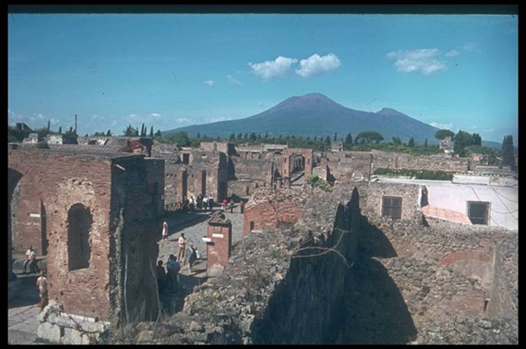 Via del Foro between VII.5 and VII.4. Looking north towards Vesuvius, from top of scaffolding in shop VII.9.9 on the Forum.  Photographed 1970-79 by Gnther Einhorn, picture courtesy of his son Ralf Einhorn.

