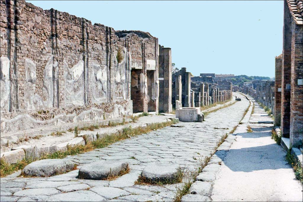 Via dell’ Abbondanza, Pompeii. June 1962. Looking east between VII.9, on left, and VIII.3, on right.
Photo by Brian Philp: Pictorial Colour Slides, forwarded by Peter Woods
(P43.13 POMPEII A principal street).
