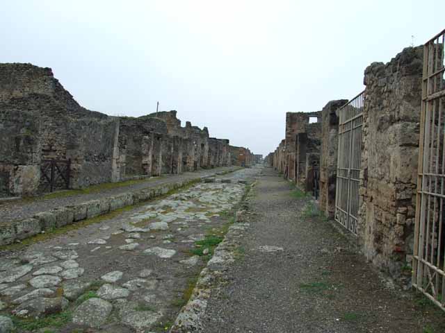 Via di Nola. South side. Looking west to junction with unnamed vicolo between III.12 and III.11. This used to be seen behind the modern built wall. May 2006.