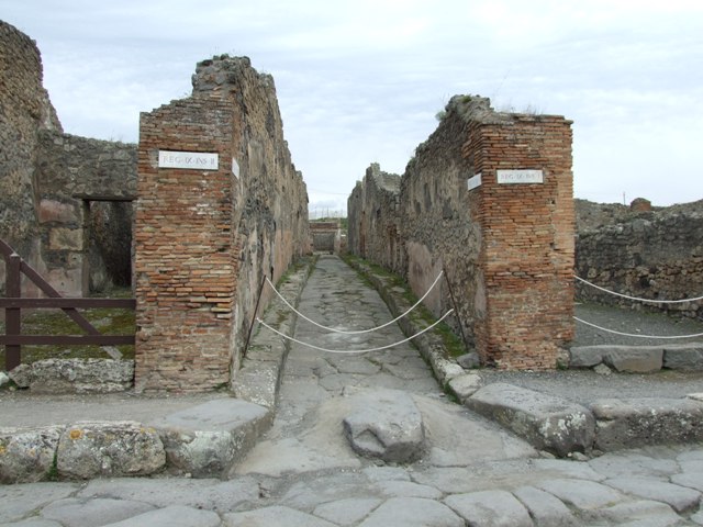 Vicolo di Balbo between IX.2 and IX.1. December 2005. North side, with street altar at IX.2.12 from Via Stabiana. Originally underneath the niche were two large painted serpents.
The roadway was originally known as Vicolo dei Serpenti. See Bulletino dell’Instituto di Corrispondenza Archeologica (DAIR), 1871, p. 205.