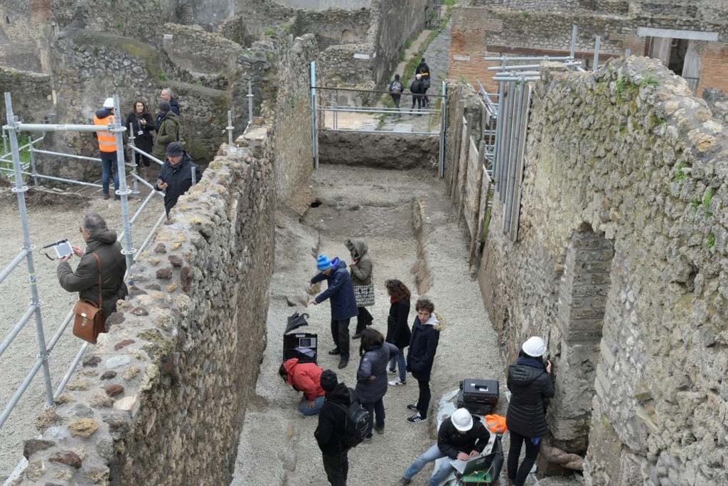 Vicolo c.d. dei Balconi, at north-west corner of junction with Vicolo delle Nozze Argento. June 2018. 
Last entrance to the east on the north side of Vicolo delle Nozze Argento with impression of doors in the ash and electoral inscription. 
Photograph courtesy of Parco Archeologico di Pompei.
