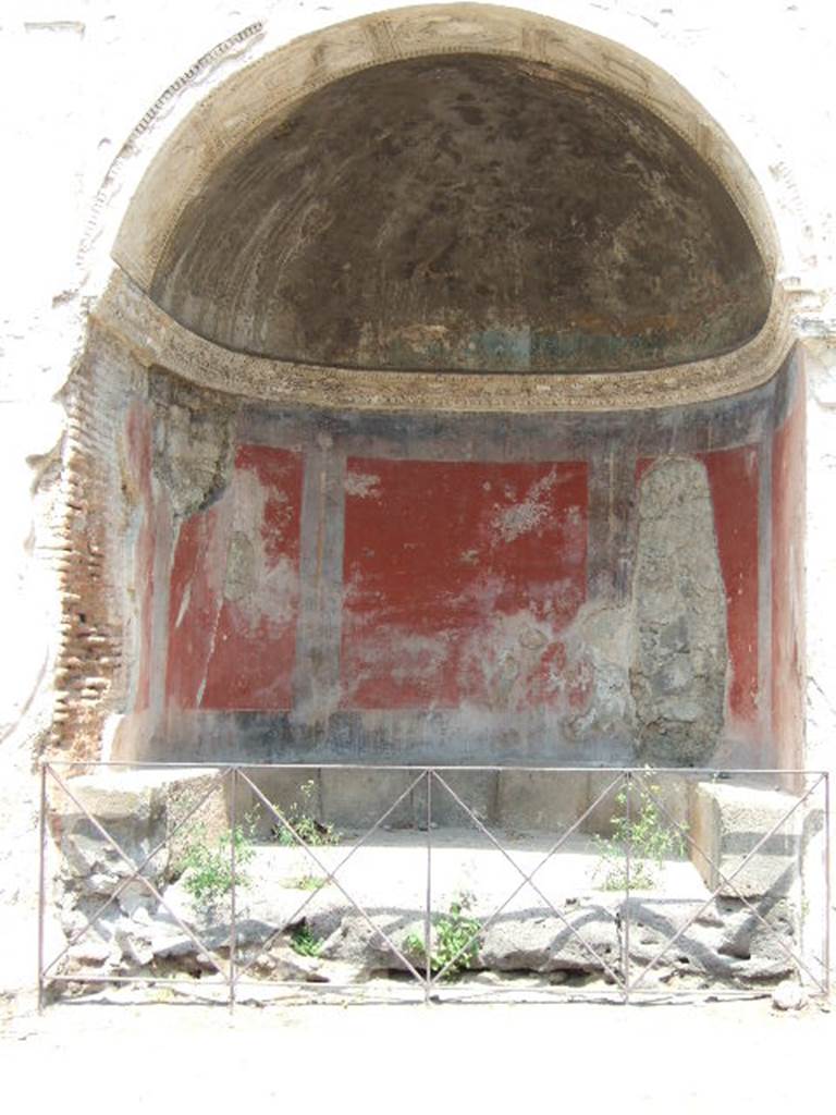 HGE09 Pompeii. May 2006. Inside the niche of the tomb with the seat, stuccowork and red painted walls. According to Mau the curved ceiling was covered in stucco (now fallen) moulded in the form of a shell. See Mau, A., 1907, translated by Kelsey F. W. Pompeii: Its Life and Art. New York: Macmillan. (p. 417).