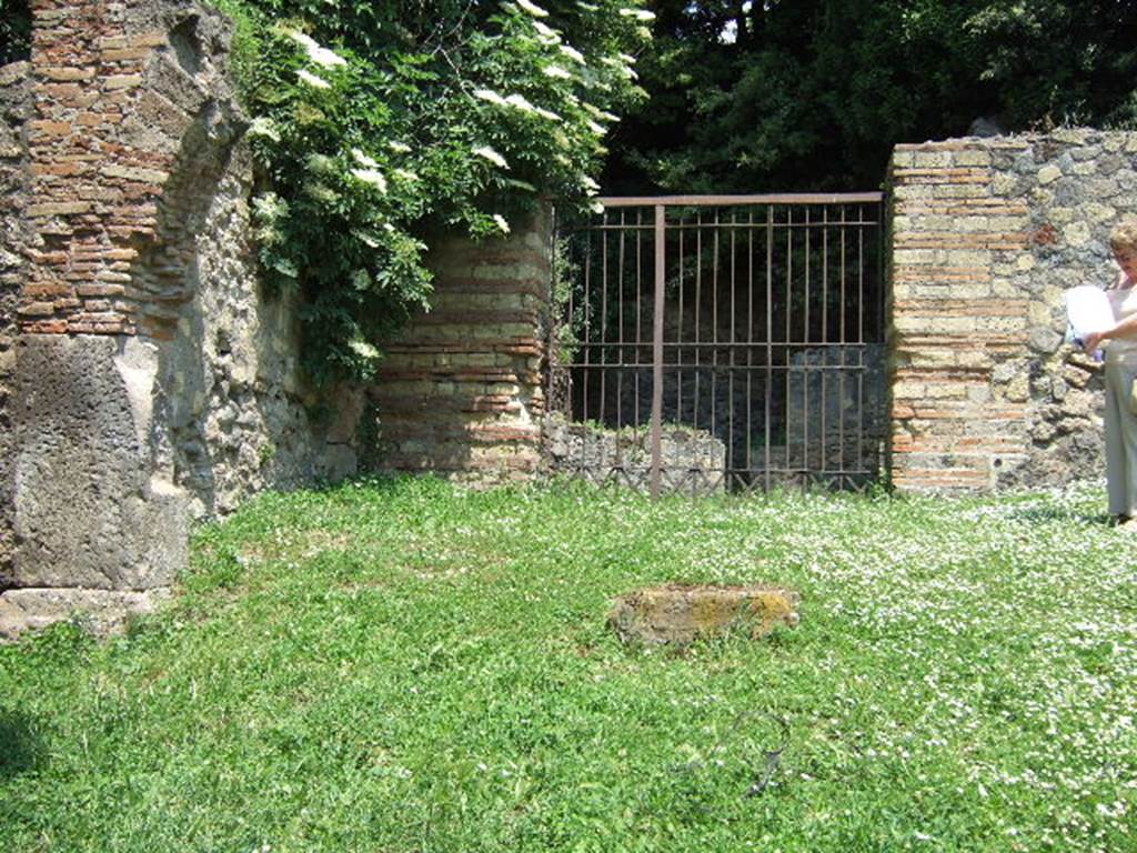 HGE29 Pompeii. May 2006. Looking east to entrance doorway to rooms 1 and 2.
According to Mau, a potter’s workshop with two ovens was located here. The ovens which were not large, had an upper division in which were placed the vessels to be baked. Beneath this was a firebox, underneath the floor above being pierced with holes to let the heat through. The vault of one of the ovens was constructed of parallel rows of jars fitted into one another. See Mau, A., 1907, translated by Kelsey, F. W., Pompeii: Its Life and Art. New York: Macmillan. (p. 386).
According to Garcia y Garcia, a bomb fell during the night of 18th September 1943 thoroughly hitting the workshop. This destroyed the two rooms, 29 and 30,  with their respective ovens. See Garcia y Garcia, L., 2006. Danni di guerra a Pompei. Rome: L’Erma di Bretschneider. (p.163)
