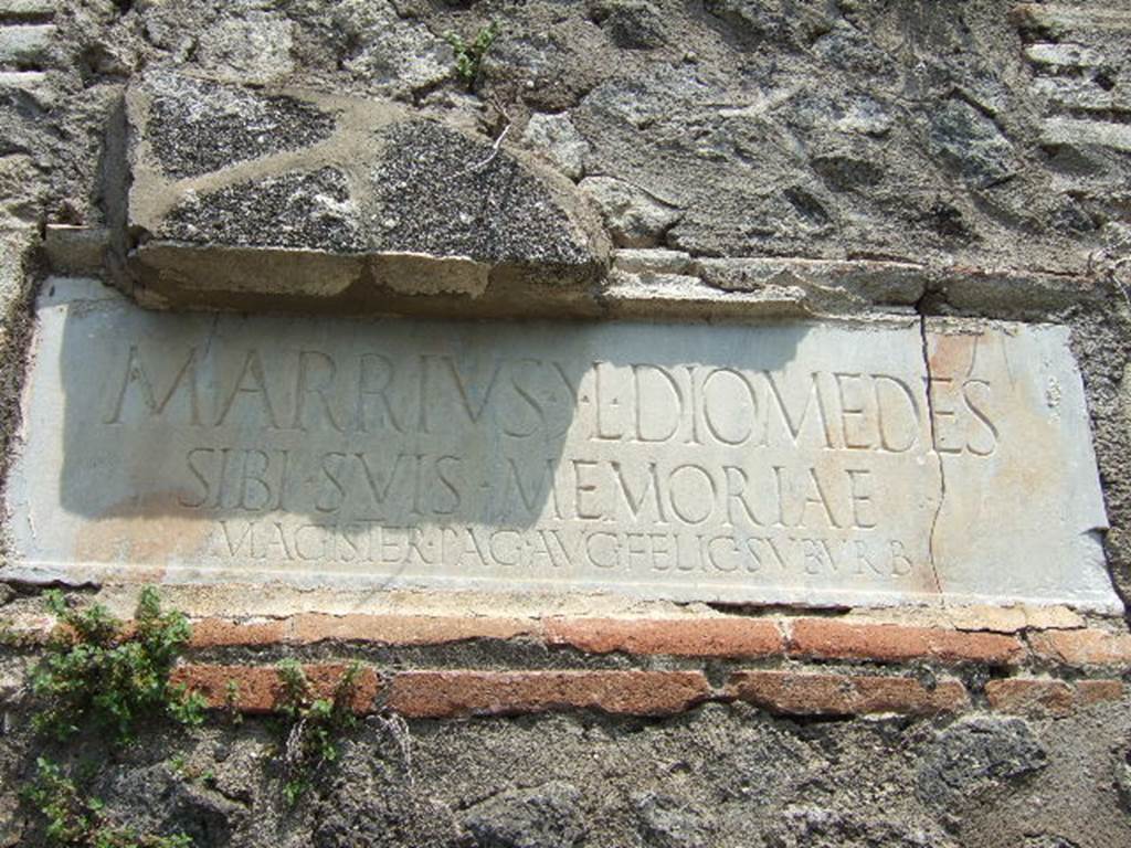HGE42 Pompeii. May 2006. Marble plaque on front west side of tomb. The inscription reads -
M ARRIVS M L DIOMEDES
SIBI SVIS MEMORAIE
MAGISTER PAG AVG FELIC SVBVRB    [CIL X 1042]

According to Epigraphik-Datenbank Clauss/Slaby (See www.manfredclauss.de) this reads

M(arcus) Arrius (mulieris) l(ibertus) Diomedes
sibi suis memoriae
magister pag(i) Aug(usti) felic(is) suburb(ani)      [CIL X 1042]

According to Cooley, this translated as 
Marcus Arrius Diomedes, freedman of a woman, (set this up) to himself and his family to their memory;
President of the Fortunate Augustan Suburban Country District.
See Cooley, A. and M.G.L., 2004. Pompeii : A Sourcebook. London : Routledge. (p.132)


