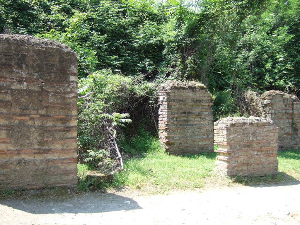 HGW11 Pompeii. May 2006. Looking north-west through portico towards shop doorways, at rear.