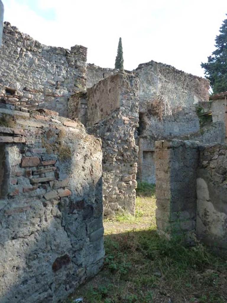 HGW25 Pompeii. September 2015. Looking into servants quarters, room with lararium. Photo taken from the same place as above photo, but without the overgrown bushes and trees.
