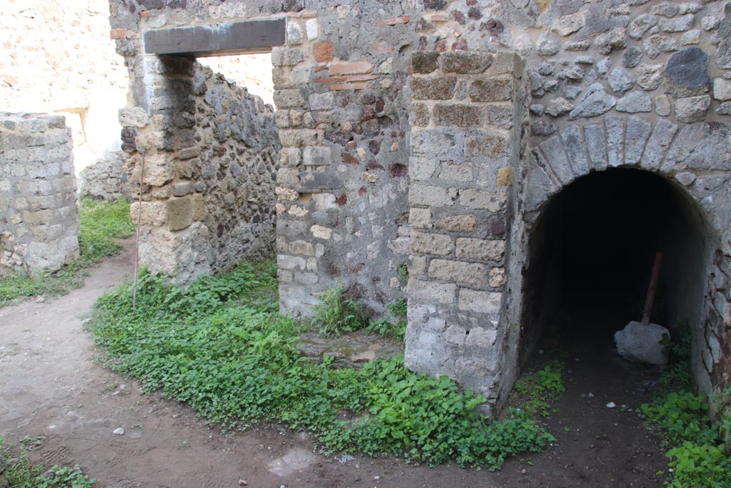 HGW25 Pompeii. Part of Villa of Diomedes. October 2023. 
East end of room 7,6 with doorway to room 7,7 and arched entrance to cellar. Photo courtesy of Klaus Heese.
