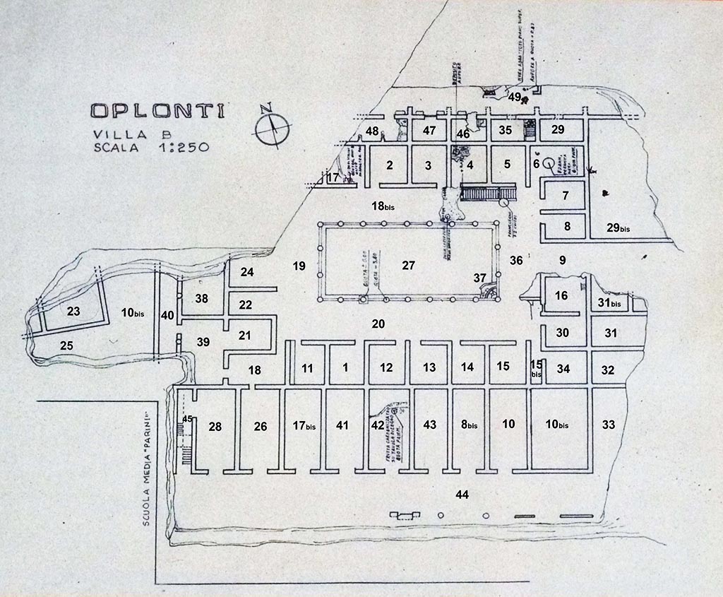 Oplontis, Villa of Lucius Crassius Tertius. Plan on display in Oplontis in 2011. 
(Click on plan for larger version)
Detail from photo courtesy of Michael Binns.
The structure’s plan reveals a central courtyard surrounded by a two-storey peristyle of Nocera tufa columns.  Excavators uncovered and restored more than seventy rooms, on both ground- and second-story levels. 
On the ground level, barrel-vaulted rooms, each with a single large doorway, line all four sides of the courtyard.  These ground-floor rooms preserve little or no decoration and reveal masonry predominantly in opus incertum and opus reticulatum. Excavators found remnants of a wooden stairway to the upper floor at the northeast corner of the peristyle; its impression is still visible in the wall plaster.  At the south corner, a low structure comprised of thin rubble walls may have been a latrine.  
The eastern side preserves what seems to be the primary entrance into the courtyard.  
On the south side of the building, and facing south, eight storerooms open onto a what may have been a large portico.  
To the west stand the partially-excavated remains of two rooms that belong to another building.  
To the north, a small street separates Villa B from what appears to be a row of two-storied houses (also only partially excavated) that faced the north side of the villa.  
During coring operations sponsored by the Oplontis Project in 2009 and 2010, geologist Giovanni di Maio found evidence of a road to the east of the villa, in an area that is still unexcavated. This road is likely to be a north-south road running along the eastern facade of the complex; it was probably from this road that one entered the courtyard.
A preliminary examination of the remains suggests that Villa B was originally constructed at the end of the second century B.C.E., as evidenced by the use of Nocera tufa columns typical of that period.  Brick repairs to that peristyle and the extensive use of opus reticulatum—both typical of post-62 C.E. earthquake construction at Pompeii—may suggest a renovation of the structure in the years before the eruption of 79 C.E.
Villa B preserves very little evidence of decoration.  Only simple white plaster of a type common to utilitarian spaces in Roman buildings survives on the ground floor.  The upper-floor rooms preserve some simple painting schemes, most datable to the Fourth Style (C.E. 45-79). These include simple designs of colour fields with carpet borders. There is a fragmentary Nilotic painting, later covered by Fourth-Style painting, as well as a painted lararium.  Preserved in another room  is a fragment of schematic Second-Style decoration (ca. 50 B.C.E.), a carry-over from an earlier decorative phase.
See http://www.oplontisproject.org/index.php/the-villas/villa-b/
