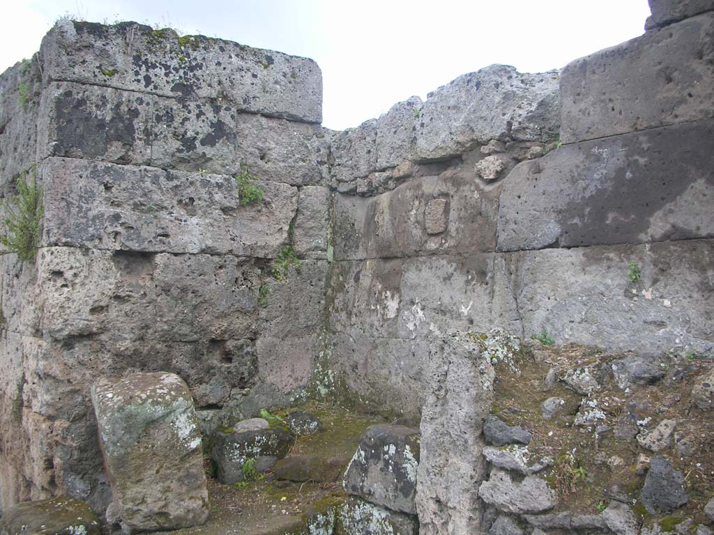 Vesuvian Gate Pompeii. May 2010. Looking south-west at north end of west wall. Photo courtesy of Ivo van der Graaff.
According to Van der Graaff –
“The Porta Vesuvio displays the remains of two altars in the cul-de-sac on the exterior north-west tip of the gate. 
Upon excavation in the early twentieth century, it preserved the remains of a plaster coating and a fresco associated with the altars. 
Any identifiable signs had already deteriorated beyond recognition and have now completely disappeared. 
Antonio Sogliano identified the shrine as a lararium and the fresco presumably depicted the public lares protecting the city (Note 18). 
However, given the prevalence of Minerva on the other gates, it seems plausible to assume that she played a role here as well.”
See Van der Graaff, I. (2018). The Fortifications of Pompeii and Ancient Italy. Routledge, (p.211 and Note 18).
