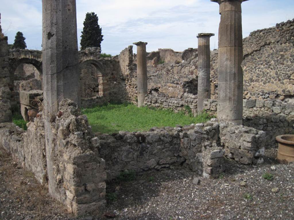 I.3.8b Pompeii. September 2010. Looking towards north-west corner of peristyle, from south-east corner. Photo courtesy of Drew Baker. According to Trendelenburg -
I must mention the hearth of the peristyle that one finds near to a column of the east side, the vault of which was surmounted by a decoration, that I do not know, and until now is new in Pompeii. It is worth saying it was of a small bearded head with a pileus or falet cap. 
It was crudely formed in terracotta and seemed to be made of the same bricks that made the hearth. Originally, above the head was a phallus (see GdS, 3 Sett.1869) that is missing today, and also missing is the glass paste, that made the eyes distinct. 
The decoration is reputedly the head of Vulcan that elsewhere we see attributed to Vesta, as the tutelary god of the hearth. See Trendelenburg in BdI, 1871, (p.171-2)

