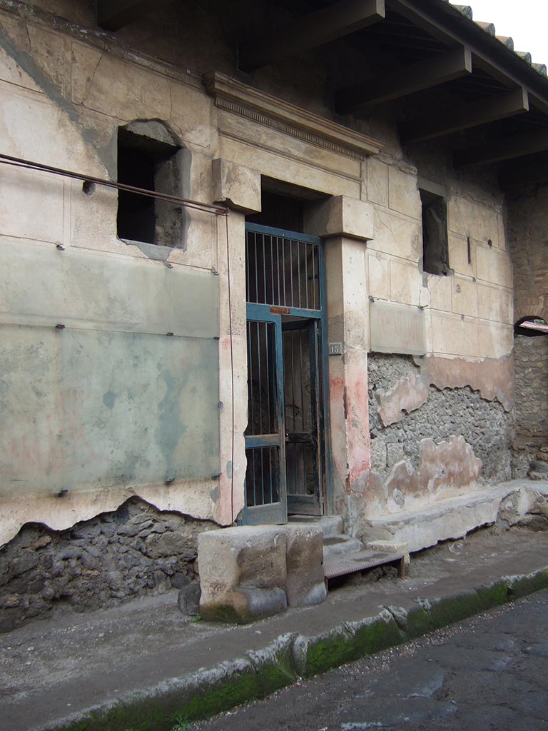 I.6.15 Pompeii. December 2005. Entrance on Vicolo del Menandro.
According to Varone and Stefani, there were many graffiti written on both sides of the doorway.
On the west side (left of the doorway) CIL IV 7187, 7191, 7188 and 7189.
Only part of CIL IV 7188 and 7189 remain on the left.
On the east side (right of the doorway) CIL IV 7190, 7192, 7193 and 7194.
Only part of CIL IV 7190 and 7192 remain on the right.
See Varone, A. and Stefani, G., 2009. Titulorum Pictorum Pompeianorum, Rome: L’erma di Bretschneider, (p.63-68)

According to Epigraphik-Datenbank Clauss/Slaby (See www.manfredclauss.de), these read as:

L(ucium)  Sextilium
IIvir(um)  i(ure)  d(icundo)
[...]  multis  fecit  benigne      [CIL IV 7187]

Cn(aeum)  Helvium  Sabinum  aed(ilem)  Infantio  rog(at)  cum  suis     [CIL IV 7191] 
Translated as
Infantio with his household asks for Cn. Helvius Sabinus as aedile.
See Cooley, A. and M.G.L., 2004. Pompeii: A Sourcebook. London: Routledge. (p.122, F47 CIL IV 7191)

Pansam  aed(ilem)  o(ro)  v(os)  f(aciatis)      [CIL IV 7188]

C(aium)  Iulium
IIvir(um)  Fabia
rog(at)  o(ro)  v(os)  f(aciatis)  dignus  est      [CIL IV 7189]

C(aium)  Cornelium
aed(ilem)  Tyrsus  [ro]gat     [CIL IV 7190]

L(ucium)  Sextilium
o(ro)  v(os)  f(aciatis)      [CIL IV 7192]

Veran[ium]
quinq(uennalem)     [CIL IV 7193]

Q(uintum)  Postumium  Proc[ulum] aed(ilem)  […]cei  rog(at)     [CIL IV 7194]
