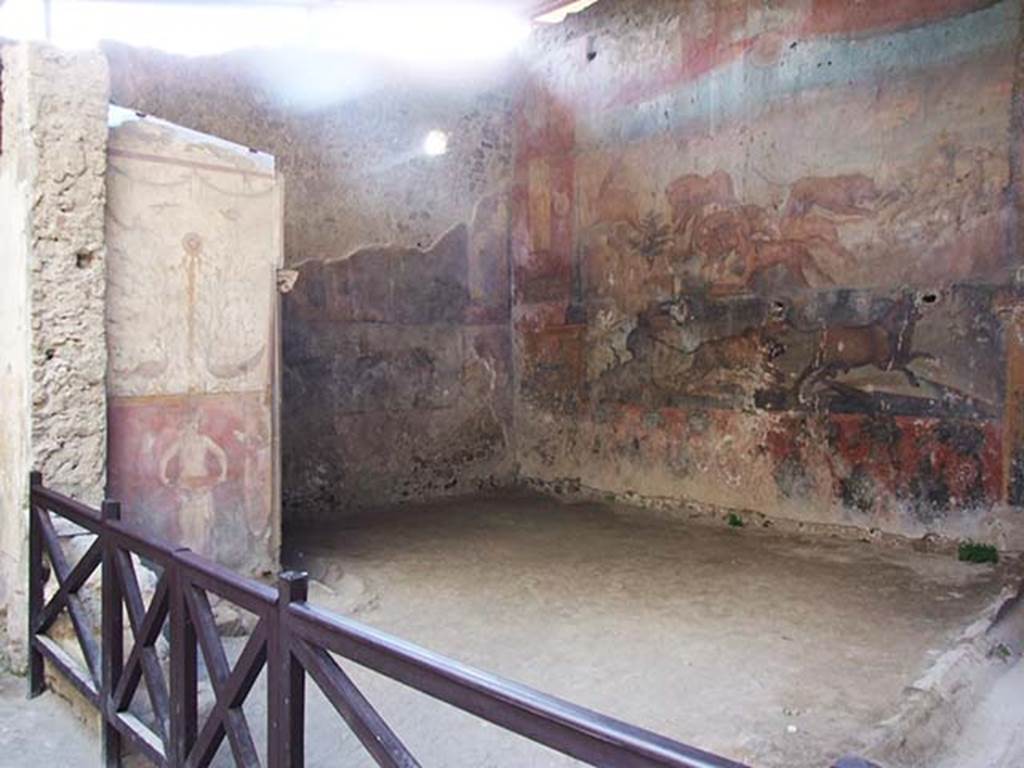 I.6.15 Pompeii. May 2009. Room 9, small arden. Looking west.
According to Jashemski –
“The small garden at the rear of the house had a portico on part of the south side. 
A gutter along the east and south sides carried water to the cistern. 
The best-preserved animal painting in Pompeii is on the rear wall. 
Three large holes had been cut in the painting in order to install fittings for garden lights. 
There is a garden painting on the lower part of the wall on each side of the animal painting. 
Garden motifs also decorate the outside walls of the apotheca (store-room) in the south-west corner of the garden. 
The east and west walls of the garden are each decorated with a large Egyptian landscape. 
A marble dove (0.29m long) found in the kitchen may have been a garden decoration.”
See Jashemski, W. F., 1993. The Gardens of Pompeii, Volume II: Appendices. New York: Caratzas. (p.36)
