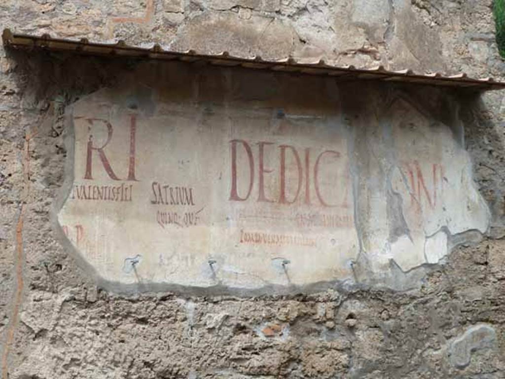 III.2.1 Pompeii. May 2010. Graffiti.  The wall on the east side of the entrance was devastated by a bomb landing to the south-east of the house in the Via dell’Abbondanza, in 1943. A small portion of the writings on the east side were saved, restored and can still be read today. 
According to Della Corte, some of the inscriptions on the east side of the doorway to confirm the house as belonging to Trebius Valens, were –
Trebi,  surge,  fac    [CIL IV 7624]
Trebius  facit    [CIL IV 7630]
Trebi  et  Soteriche, vigilate    [CIL IV 7632]
Trebius  nec  sine  (Soterico?)    [CIL IV 7627]
He also thought these proved that Sotericus was a near neighbour, from III.2.2 and also across Via dell’Abbondanza at I.12.1/2.
See Della Corte, M., 1965.  Case ed Abitanti di Pompei. Napoli: Fausto Fiorentino. (p.345)
According to Epigraphik-Datenbank Clauss/Slaby (See www.manfredclauss.de), these read as -
Ampliatum  aed(ilem)  
Trebi  surge 
 fac(it)    [CIL IV 7624]
Cuspium  Pansam 
aed(ilem)  v(iis)  a(edibus)  s(acris)  p(ublicis)  p(rocurandis)  d(ignum)  r(ei)  p(ublicae)  o(ro)  v(os)  f(aciatis)  Trebius  fac(it)    [CIL IV 7630]
L(ucium)  Popidium  L(ucium)  f(ilium)  Ampliatum  aed(ilem)  o(ro)  te  fac(ias) 
Trebi  et  Soteriche  {et}  vigilate     [CIL IV 7632]
L(ucium)  Ceium  Secundum 
IIvir(um)  o(ro)  v(os)  f(aciatis)  Trebius  nec  sine     [CIL IV 7627]
According to Varone and Stefani, also lost from this wall were the following CIL IV 7621, 7622, 7623, 7625 ,7628, 7629, 7631, 7633 and 7634.
None of these have been conserved.
Fully conserved is CIL IV 7620, and partially CIL IV 7626, 7992 and 7993, see below.
See Varone, A. and Stefani, G., 2009. Titulorum Pictorum Pompeianorum, Rome: L’erma di Bretschneider, (p.235-240, with photos)
According to Epigraphik-Datenbank Clauss/Slaby (See www.manfredclauss.de), these read as -
Satrium 
quinq(uennalem) o(ro) v(os) f(aciatis)      [CIL IV 7620]
D(ecimum) L(ucretium) V(alentem) f(ilium) aed(ilem) d(ignum) r(ei) p(ublicae) o(ro) v(os) f(aciatis)     [CIL IV 7626]
D(ecimi) Lucreti Satri Valentis flaminis [Neronis] Caesaris Aug(usti) f(ilii) perpetui glad(iatorum) par(ia) XX et D(ecimi) Lucreti Valentis fili(i) glad(iatorum) par(ia) X pugn(abunt) Pompeis ex a(nte) d(iem) V Nonis Apr(ilibus) venatio et vela erunt 
// Poly[bius(?)]       [CIL IV 7992]
Dedicatione 
operis tabularum Cn(aei) Allei Nigidi Mai Pompeis Idibus Iuni(i)s 
pompa venatio athletae vela erunt 
Nigra va(le)             [CIL IV 7993]
According to Cooley, these advertisements for the gladiatorial games can be translated as –
CIL IV 7992 –
20 pairs of gladiators of Decimus (Polybius – signed by writer’s name, enclosed within the initial D of Decimus) Lucretius Satrius Valens, perpetual priest of ((Nero)) Caesar, son of Augustus, and 10 pairs of gladiators of Decimus Lucretius Valens will fight at Pomeii on 4? April. There will be a hunt and awnings.
She says that this was painted in Black and Red in around AD 50-68, and the name of Nero was plastered over, perhaps after he committed suicide in AD 68.
See Cooley, A. and M.G.L., 2004. Pompeii : A Sourcebook. London : Routledge. (p.50)
 CIL IV 7993 –
At the dedication of (Ocella) of the opus tabularum of Gnaeus Alleius Nigidius Maius, at Pompeii on the 13 June, there will be a procession, hunt, athletics, and awnings.  Greeting to Nigra (picture of a head).
She says this was painted in Red and Black, in around 59-69?
She also says there is no agreement about what the “opus tabularum” might be (see p.53)
See Cooley, A. and M.G.L., 2004. Pompeii : A Sourcebook. London : Routledge. (p.54)

