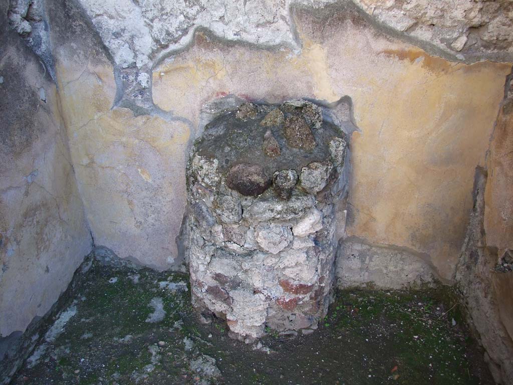 V.1.7 Pompeii. December 2007. Room 5, round altar with paintings of serpents on wall to sides.
According to Boyce, this altar is in the form of a half-column, coated with stucco and painted to represent red and yellow variegated marble.
On the yellow background of each side of the altar is painted a serpent coiling among plants.
See Boyce G. K., 1937. Corpus of the Lararia of Pompeii. Rome: MAAR 14. (p. 32, pl.39,4)

