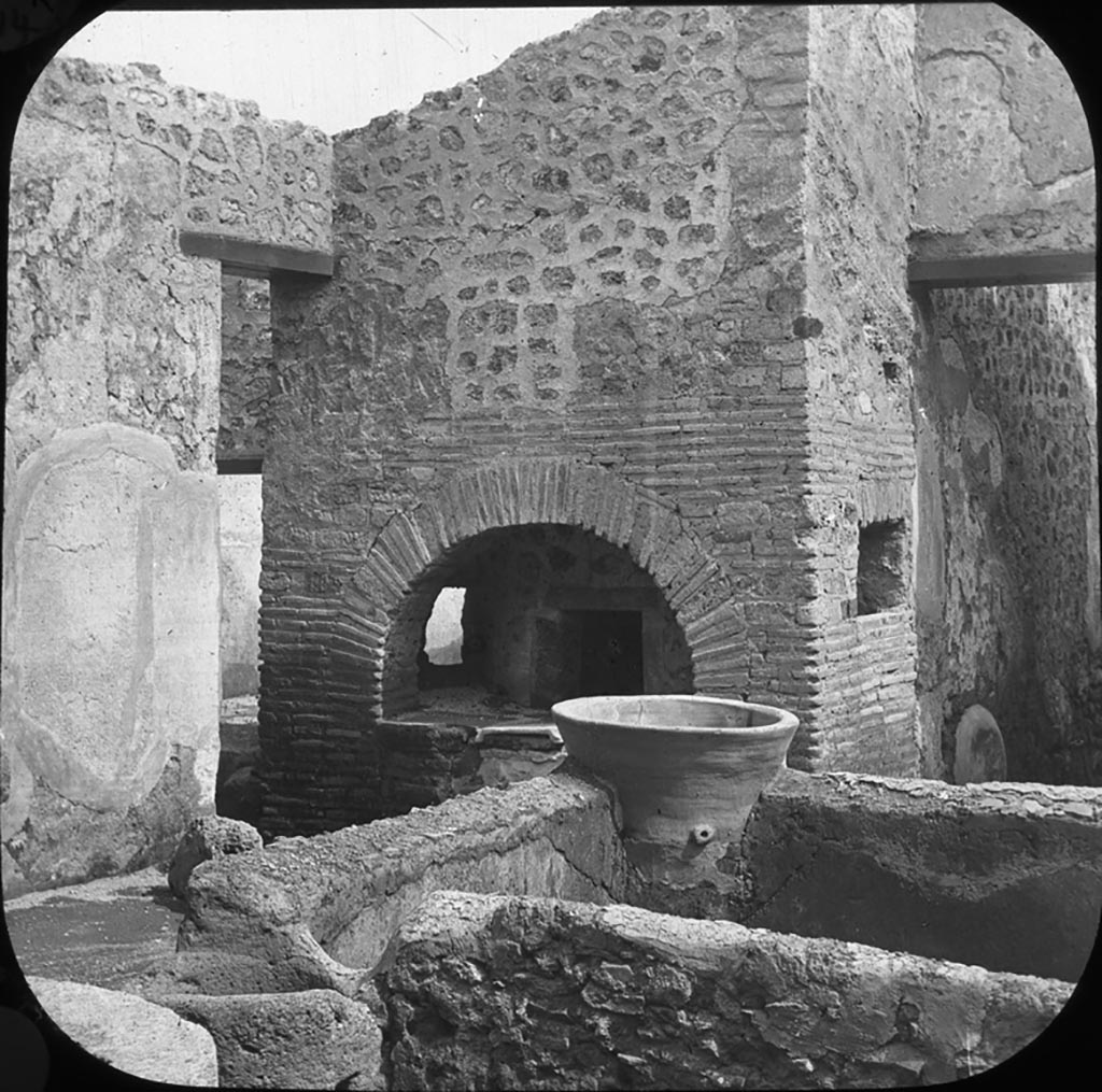 V.3.8 Pompeii. Looking south-east across bakery towards oven.
Photo by permission of the Institute of Archaeology, University of Oxford. File name instarchbx202im 061. Source ID. 44552.
See photo on University of Oxford HEIR database