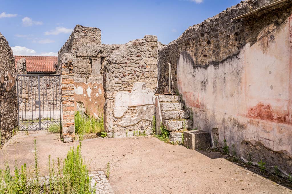 VI.7.23 Pompeii. July 2021. 
Looking towards east side of atrium with entrance doorway, doorway to small room and south-east corner with steps to upper floor.
Photo courtesy of Johannes Eber.
According to Pagano and Prisciandaro, found in March 1830 in the small room to the left of the entrance, was a small wooden box.
In the box was a seal with the letters -  

A(uli) Herenul(ei)
Communis               [CIL X 8058, 39]

See Pagano, M. and Prisciandaro, R., 2006. Studio sulle provenienze degli oggetti rinvenuti negli scavi borbonici del regno di Napoli. Naples: Nicola Longobardi. 
(p.143 and PAH II, 235; III, 104).
See Della Corte, M., 1965. Case ed Abitanti di Pompei. Napoli: Fausto Fiorentino. (p.45, S.50).

