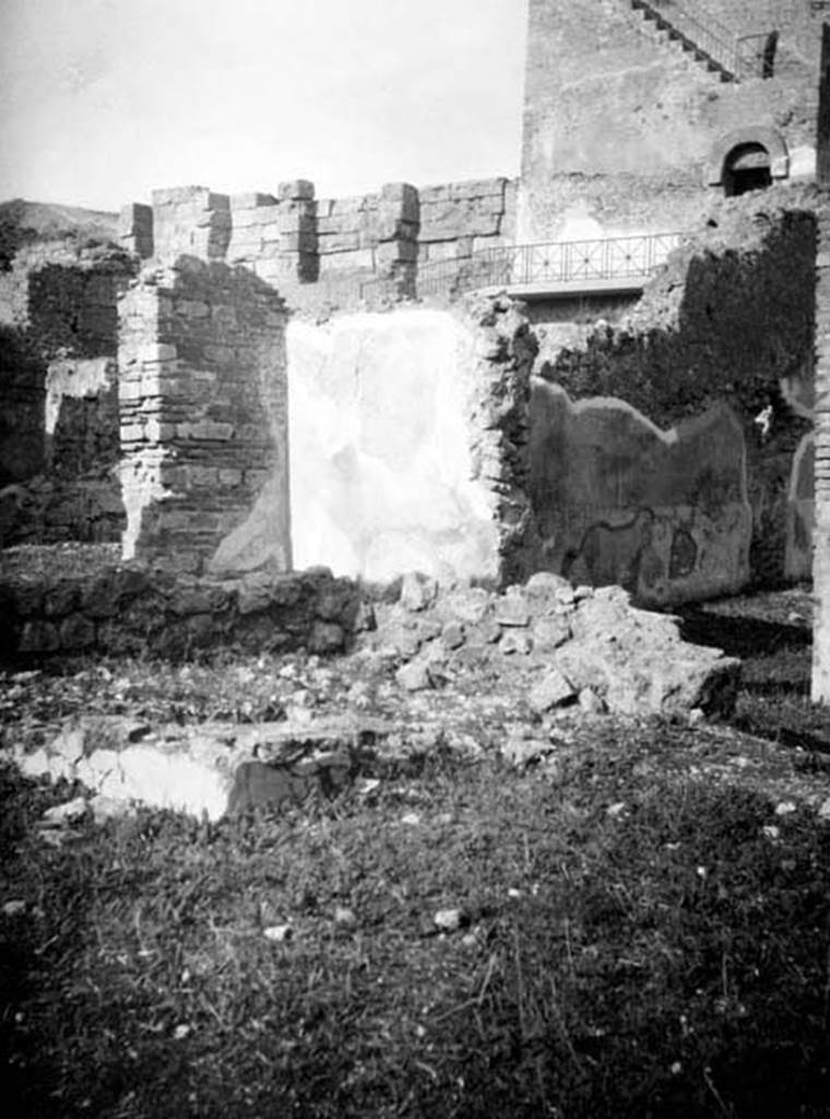 6.9.1 Pompeii. W660. Looking north-west across the walkway (room 4) on north side of garden 18. On the right, through the open doorway, are the remains of the west wall of room 11, the large oecus.
Photo by Tatiana Warscher. With kind permission of DAI Rome, whose copyright it remains. 
See http://arachne.uni-koeln.de/item/marbilderbestand/231236 
According to Warscher, this photograph showed the north-west corner of the Xystus where one could see the remains of a podium, the channel, and the mouth of the cistern.
In the background was the triclinium L.
See Warscher, T, 1938: Codex Topographicus Pompejanus, Regio VI, insula 9: Pars prima, (no.23), DAIR, Rome.  
