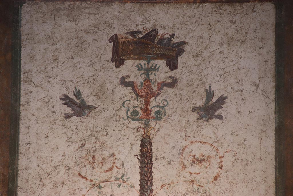 VI.15.1 Pompeii. October 2024. 
Cubiculum g, detail of painted decoration on top of candelabrum in centre of north wall. Photo courtesy of Klaus Heese.
