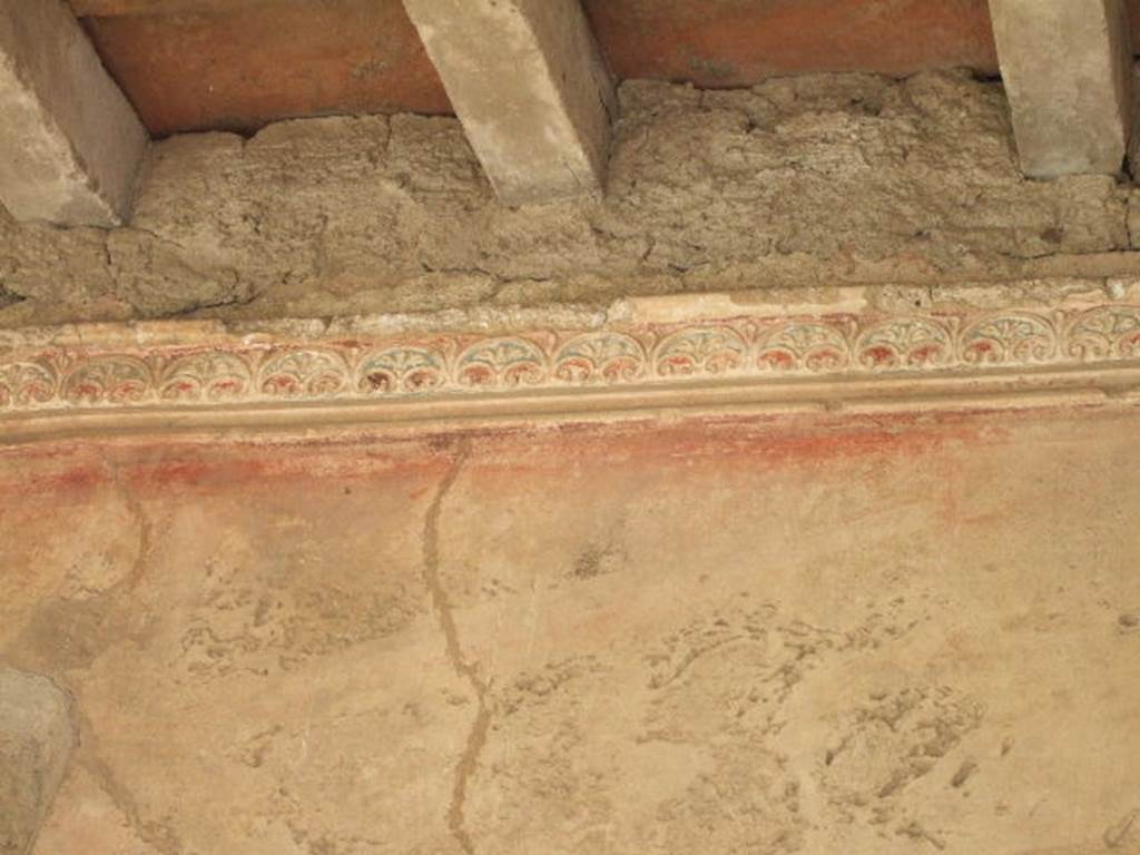 VII.1.8 Pompeii . September 2005. Detail of wall and plaster in corridor on east side of portico B.