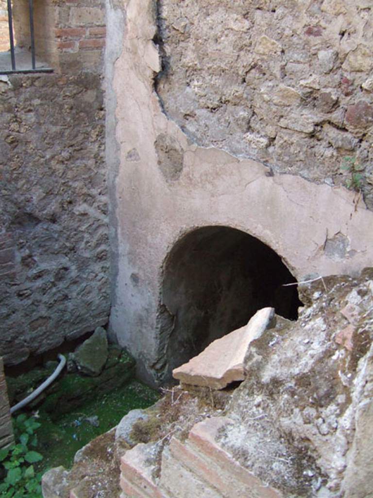 VII.1.8 Pompeii. September 2005. Room T west side. Entrance to underground corridor leading to storeroom V beneath pool D. Room V was an irregular shaped room carved into the stone below the pool. According to Eschebach, there was a great probability it was originally an Etruscan chamber grave. See Eschebach, H., in Cronache Pompeiane I, 1975, p. 97, fig. 6, fig. 18.