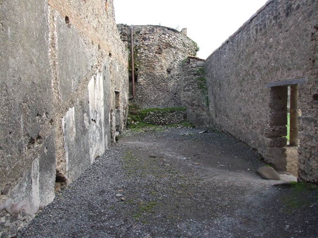 VII.1.8 Pompeii. December 2007. Room 8, anteroom of womens baths, looking south from changing room 11. Doorway leading to praefurnium 7 is on left. Doorway to east portico B and gymnasium C is on right. According to Boyce, on the east wall (left), was a painted single serpent coiling towards an altar with offerings. He described it as being above the small arched opening that passed the conduit that supplied water for the labrum of the womens calidarium 9. This would be somewhere in the vicinity of the large white patch on the wall. See Boyce G. K., 1937. Corpus of the Lararia of Pompeii. Rome: MAAR 14.  (p. 95, 472).
 
