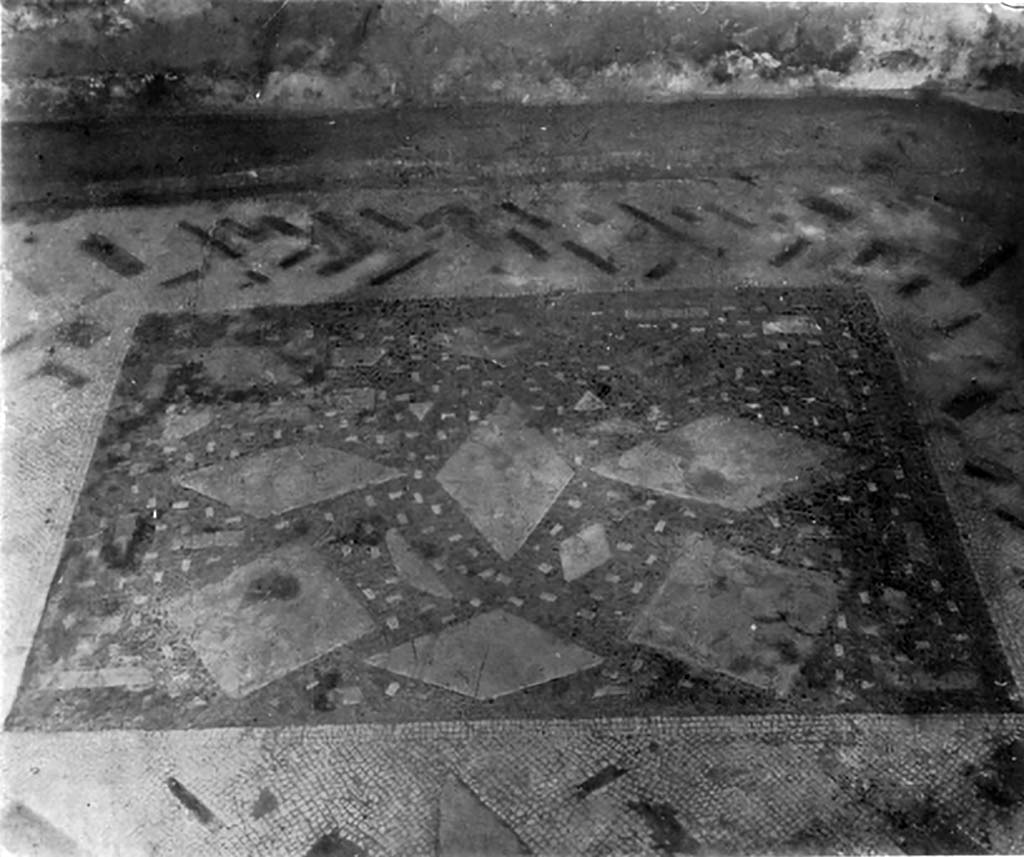 VII.7.5 Pompeii. c.1930. Flooring of central vaulted room on east side of atrium.
According to Blake –
The vaulted room to the right of the atrium of this house, through its various transformations, gives some slight help in dating this type of floor.
The original pavement was apparently a lithostroton of the Palestrina type, if one may judge by the strip composed of oblong tesserae which still remains near the back wall. Later a wall of badly wearing yellow tufa, a variety not used until the middle of the first century AD, was constructed upon the floor. The pavement is clearly earlier than the cement floor of the atrium and may well belong to the same period as those of the alae. The use of coloured marbles rather than limestones suggests the age of Augustus, or a time slightly previous. In this particular floor, there is a definite attempt to make a design even out of irregular pieces. The centre has lozenges of giallo or bigio laid in a rough pattern in the background of fine black tesserae (0.6cm to 0.07cm), while the background itself has been spotted with oblong tesserae of white. Around this runs a broad white border in which are sprinkled long narrow pieces of giallo, affricano, and rosso.
See Blake, M., (1930). The pavements of the Roman Buildings of the Republic and Early Empire. Rome, MAAR, 8, (p.61 & Pl.13, tav. 2)