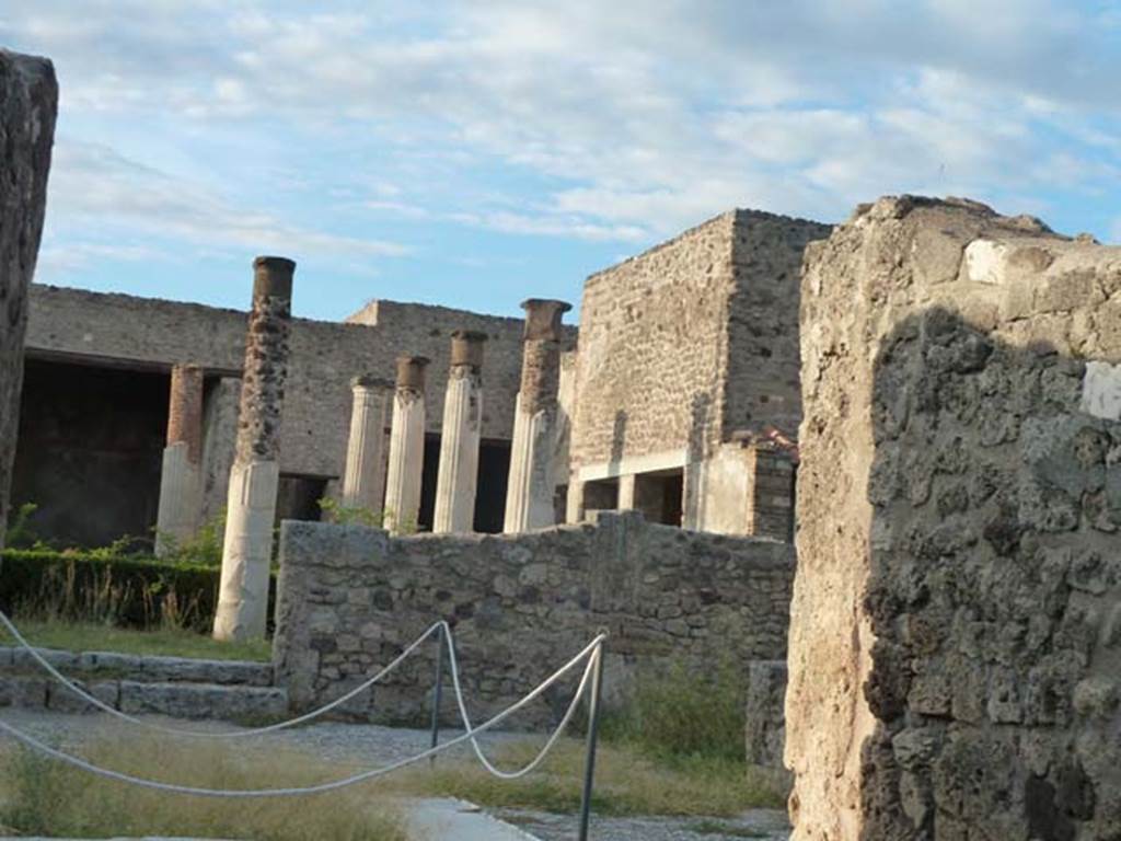 VII.7.5 Pompeii. September 2015.
Looking across east side of atrium towards rooms (m), (n) and (o) on east side of peristyle and (q) and (r) in north-east corner.
According to Garcia y Garcia, this house had a beautiful marble impluvium in the centre of its atrium.
On the night of 24th August 1943, a bomb fell causing grave damage to this house.
It destroyed a part of the floor of the atrium and a good proportion of the rooms to the east and north-east of the peristyle.
Also destroyed was a part of the south and west of the portico, comprising of two columns with painted stucco.
The perimeter wall on the west, and three rooms on the north also fell, with the ruin of the best part of the painted fourth style plaster.
In the winter triclinium (n) on the east side of the peristyle, two important paintings that decorated it, were partially destroyed.
They were of Tryptolemus and the other of Venus, they have been restored in part.
Tryptolemus was shown receiving the ears of corn from Proserpine.
Venus was shown arriving carried by a triton, with a cupid assisting her to descend to the shore.
A young woman was shown receiving her and making an offering upon a garlanded altar.
On the night of 13th September, this house linked to VII.7.2 was again hit by another bomb.
See Garcia y Garcia, L., 2006. Danni di guerra a Pompei. Rome: L’Erma di Bretschneider. (p.112-114 including photos)