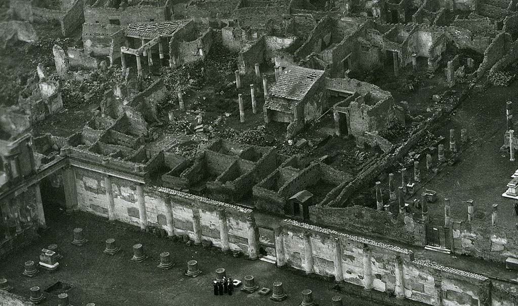 VII.7.5 Pompeii. 1944, detail taken from USAAF aerial photo. Looking north-west across the Basilica and Via Marina, lower left in photo.
On the north side of the Via Marina, in the upper part of the photo, the house of House of Romulus and Remus (VII.7.10), and House of Tryptolemus (VII.7.5 and VII.7.2) can be seen on the west side of the Temple of Apollo, which is on the right.
Photo courtesy of Rick Bauer.